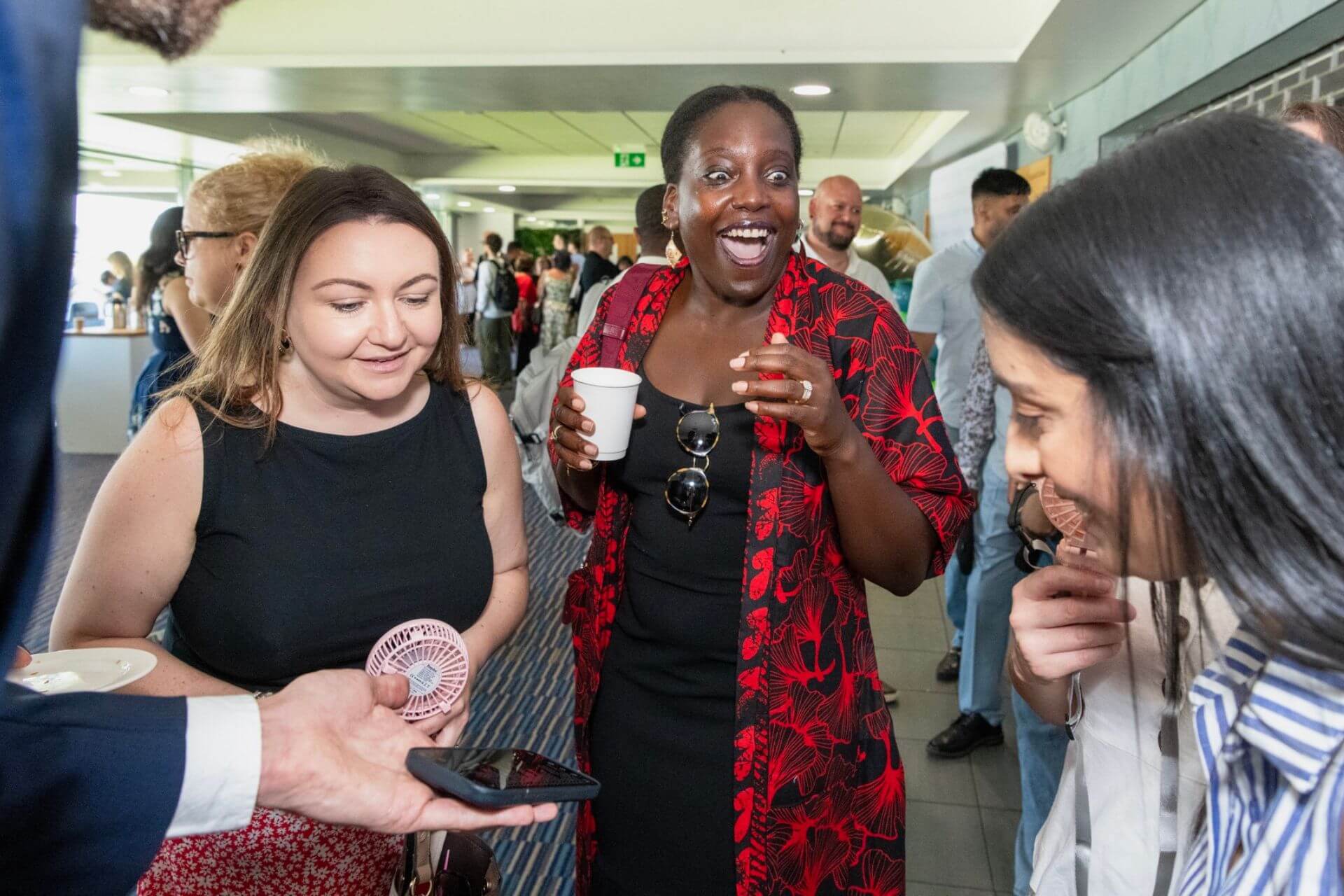 Colleagues at a daytime corporate event reacting to close-up magic