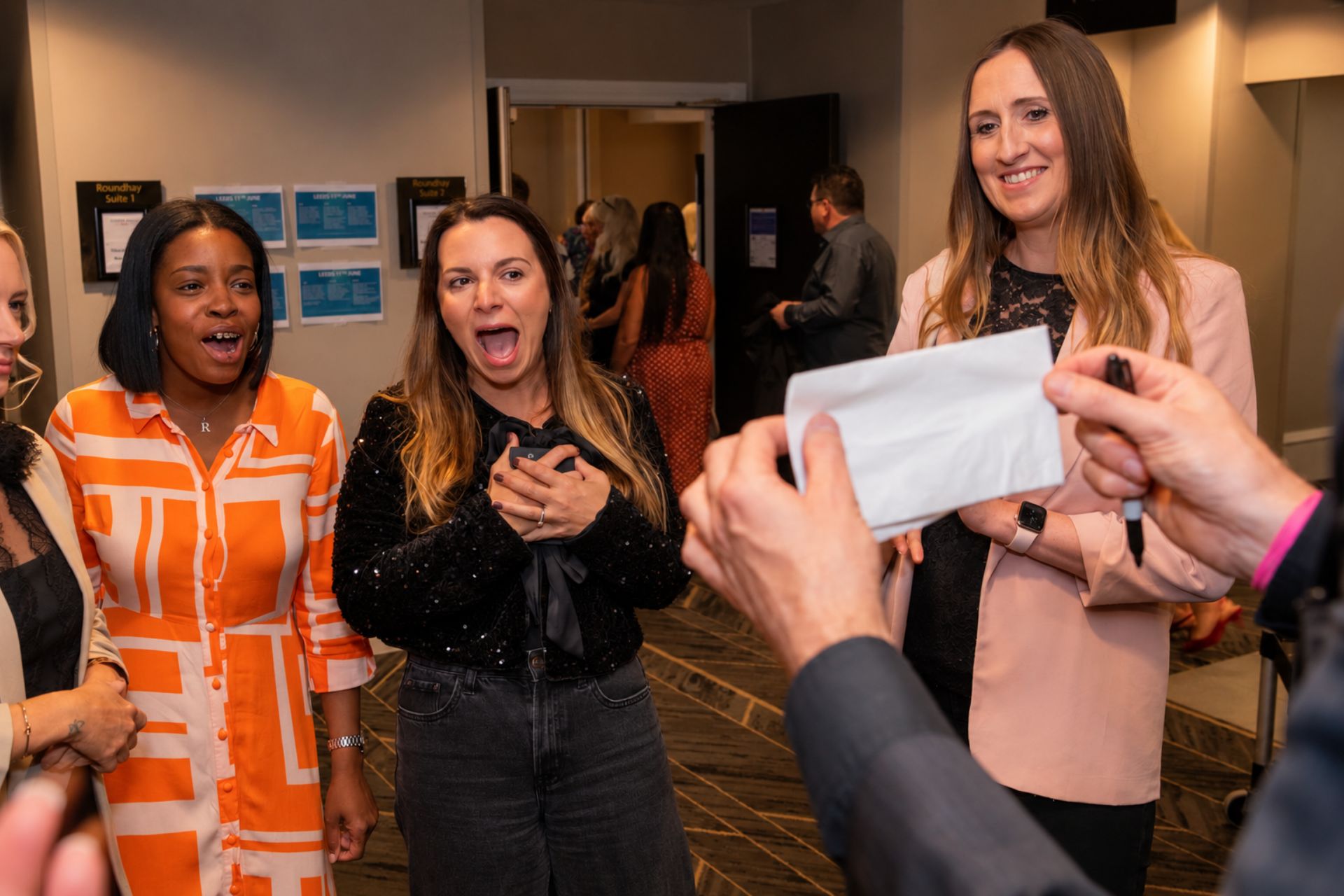 Guests reacting as a written prediction is revealed on a card