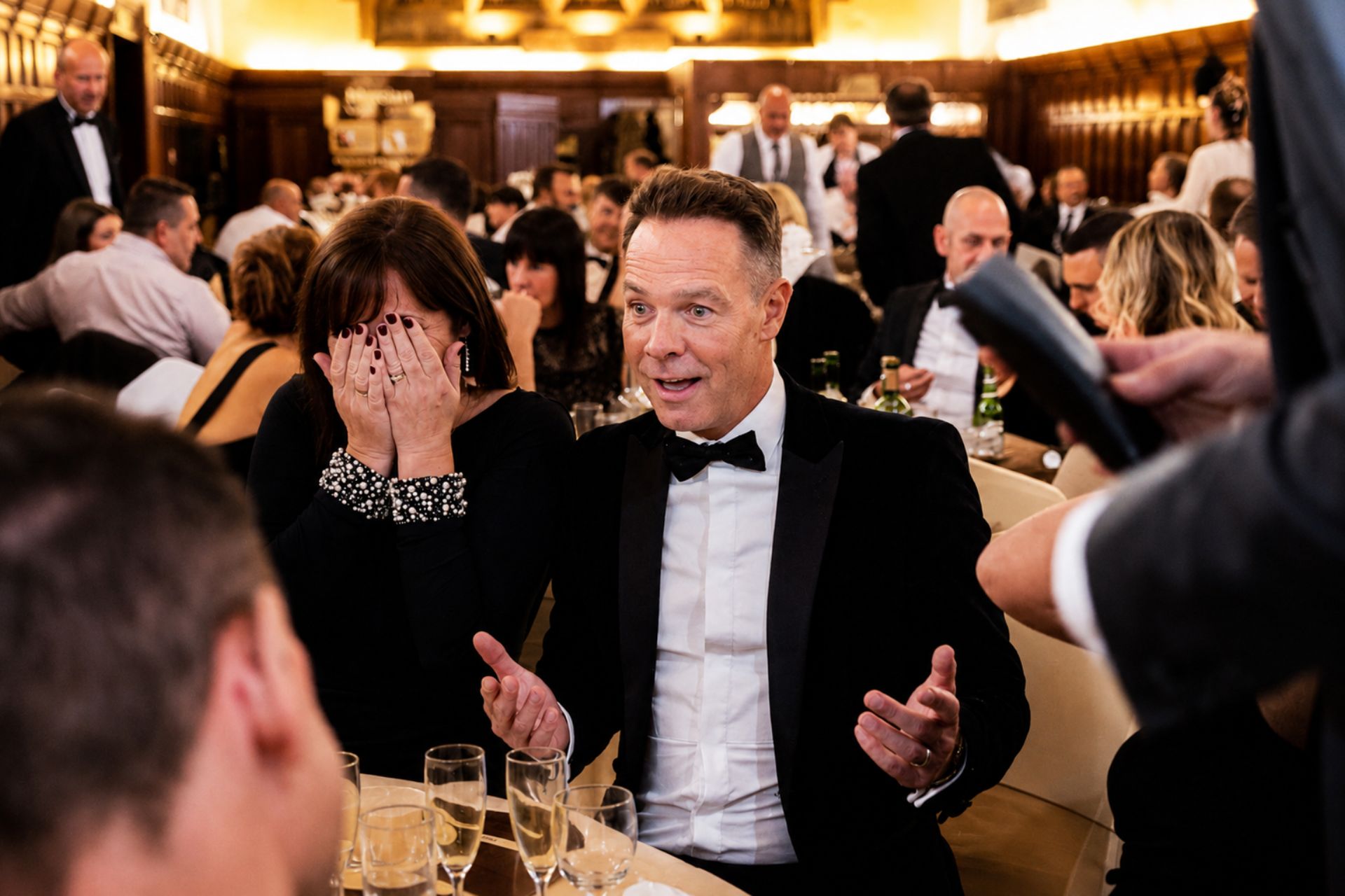Guests reacting to close-up magic at a Christmas party
